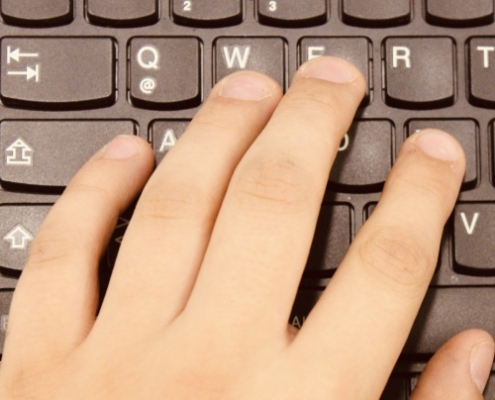 Hand tippt auf Tastatur